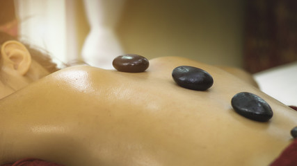Fototapeta na wymiar Asian beautiful female relaxing with hot stone therapy massage