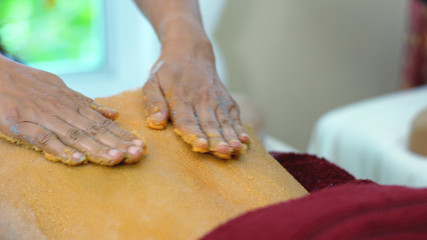 The spa therapist used scrup salt orange on back woman