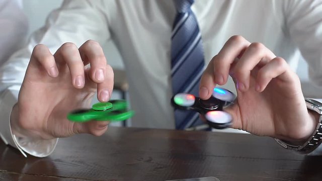 Young man playing with two fidget spinners. slow motion