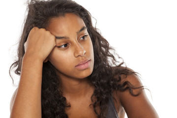 Lonely and sad dark skinned young girl on white background