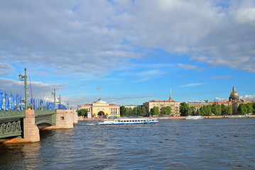 Obraz premium Palace bridge, decorated with flags of the Confederations Cup and tourist boat on the background of the Admiralty embankment