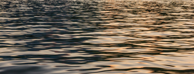 Half Blue, Half Golden Light reflection on river wave ripples surface. Abstract, tranquility, romance.