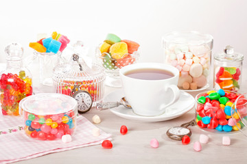 Cup of tea with assorted colorful candies for kid's birthday