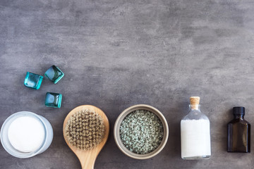 SPA cosmetics, woman body and skincare products on gray. Top view