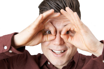 Studio Shot Of Man Making Spectacle Shape With His Hands
