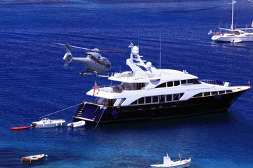 A helicopter transporting people to a motor boat