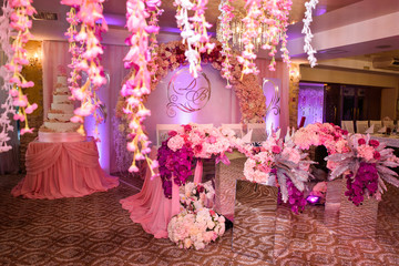 Refined decoration of a wedding fresh flowers. Wedding presidium. A table of newlyweds and a beautiful background with illumination. Wedding details. Luxury wedding flowers