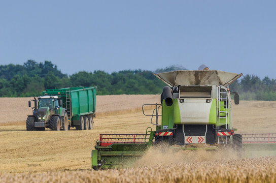 AGRICULTURAL MACHINERY - Harvester and tractor on the field