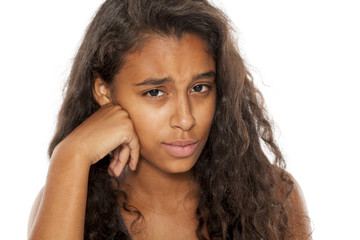 Lonely and sad dark skinned young girl on white background