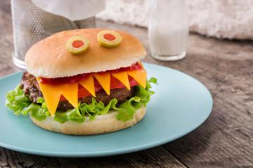 Halloween burger monsters on wooden table
