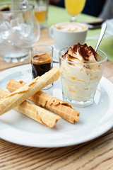 Italian dessert Tiramisu served in original manner. Tiramisu served in glass with coffee and biscuits. - 169679736