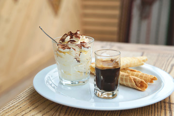 Italian dessert Tiramisu served in original manner. Tiramisu served in glass with coffee and biscuits. - 169679759