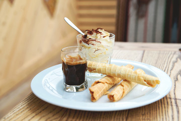 Italian dessert Tiramisu served in original manner. Tiramisu served in glass with coffee and biscuits. - 169679787