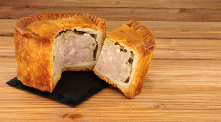 Crusty savoury pork pie on a wood background