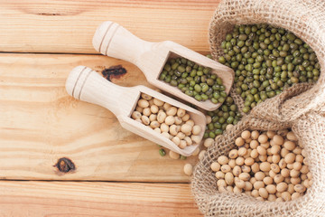 Whole grains in wood scoop on wooden table.