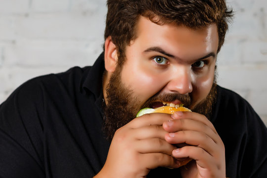 Fat Man Greedily Eating Hamburger, on white background