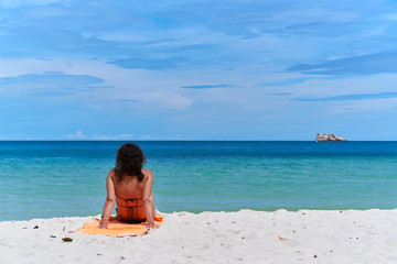 Fototapeta na wymiar Women sit in the Sun on the beaches with beautiful blue sky.