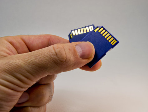 man hand holding a memory card on a white background. for information technology concept