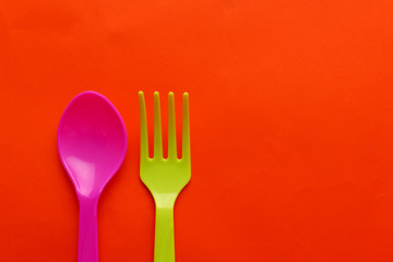 Colorful plastic spoon isolated on orange background.