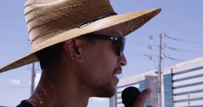 Black protestor talking into microphone outdoors