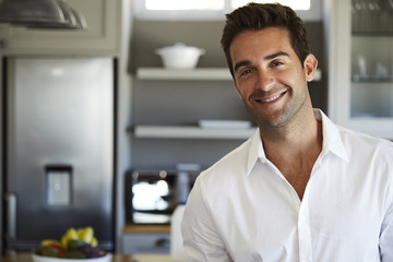 Happy guy in white shirt in kitchen, portrait