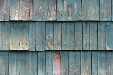 Weathered old wooden shake siding on house.