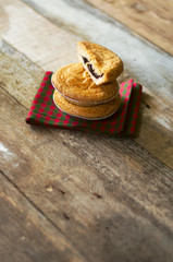 Slice of a delicious basque cake filled with cherries put on a fabric with tile and wooden boards.