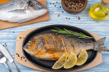 Grilled dorado in pan on wooden Background