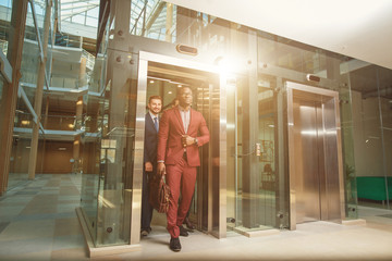 Business team going on elevator and talking