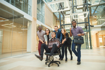 excited business people group team push colleague leader sitting in chair