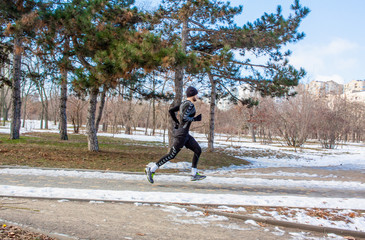 young runner training outdoor in winter park 