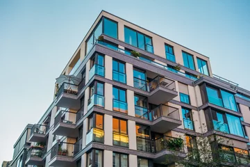 Foto op Plexiglas modern corner apartment complex with blue colored windows and light leaks © Robert Herhold