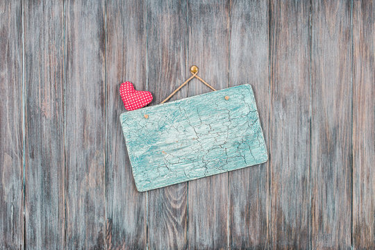 Signboard blank with love heart on vintage grunge textured planks wall background. Retro old style filtered photo