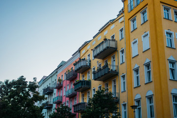 Fototapeta na wymiar orange, pink and grey facaded buildings in a row at berlin