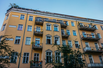 Fototapeta na wymiar orange apartment house with green trees at prenzlauer berg, berlin