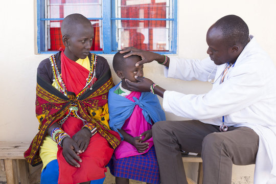 Doctor examining child patient (Maasai tribe). Kenya, Africa.