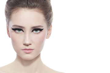 Fototapeta premium Hi-key portrait of young beautiful girl with stylish cat eye make-up over white background, copy space