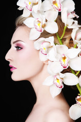 Profile portrait of young beautiful woman with white orchid