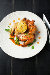 Fried quail with sauce and spices on a white plate