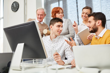 Business Team diskutiert am Computer