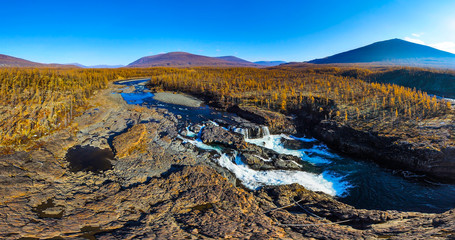 Aerial panorama of the autumn mountains landscape. Waterfall in the National park Putorana in Siberia. Nature and ecology concept.