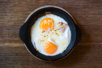 Fried egg in a frying pan, on an old wooden table
