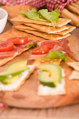 Crackers with ham and avocado. 