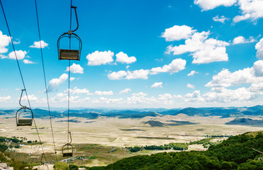 Cable car on ropeway leading to mountains.