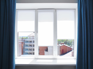 Modern white plastic window with roller blinds in flat