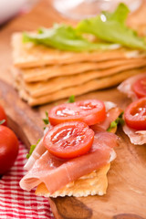 Crackers with ham and avocado. 