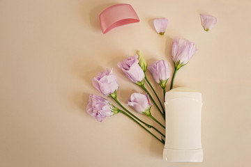 Composition with female deodorant and flowers on light background