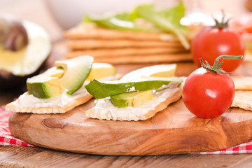Crackers with ham and avocado. 