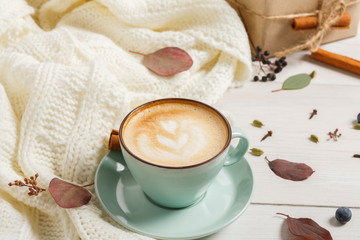Autumn cappuccino coffee cup on white wood background