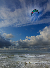 Kitesurfer against blue cloudy sky
